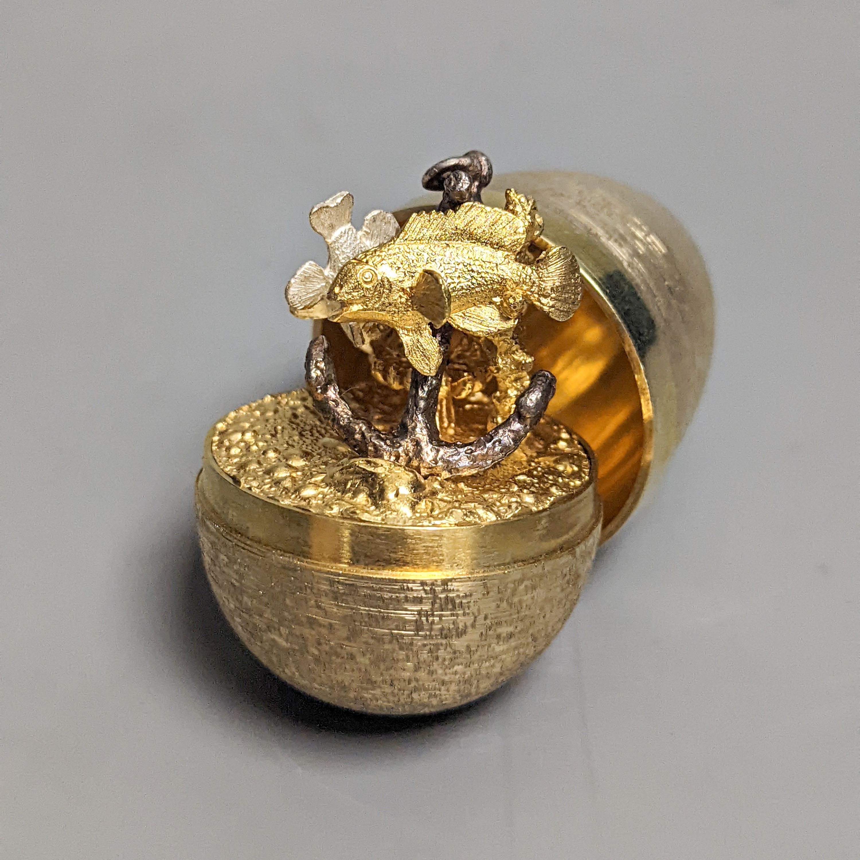 A 1970's textured silver gilt surprise egg by Stuart Devlin, opening to reveal a ship's anchor with fish, London, 1977, 71mm, no box or certificate.
